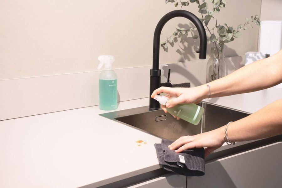 A professional cleaner at work in a modern kitchen